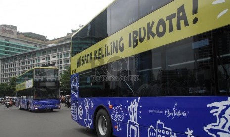  Armada bus tingkat pariwisata melintas di kawasan Bundaran HI, Jakarta Pusat, Kamis (16/1).   (Republika/Rakhmawaty La'lang)