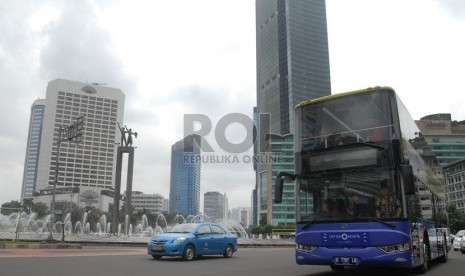  Armada bus tingkat pariwisata melintas di kawasan Bundaran HI, Jakarta Pusat, Kamis (16/1).   (Republika/Rakhmawaty La'lang)