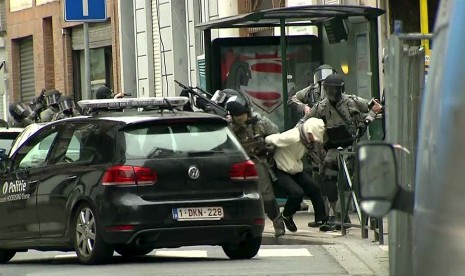 Armed Belgian police apprehend a suspect, in this still image taken from video, in Molenbeek, near Brussels, Belgium, March 18, 2016. 