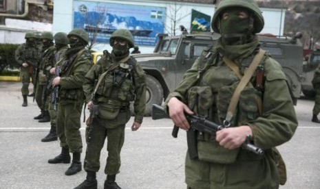 Armed servicemen stand near Russian army vehicles outside a Ukrainian border guard post in the Crimean town of Balaclava March 1, 2014.