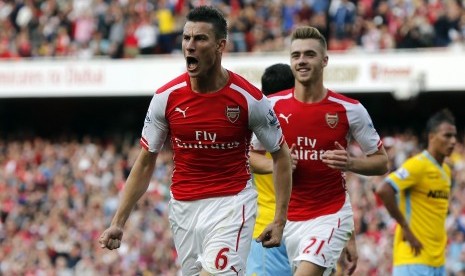 Arsenal's Laurent Koscielny (front) celebrates after scoring against Crystal Palace during the English Premier League soccer match at the Emirates stadium in London August 16, 2014. 