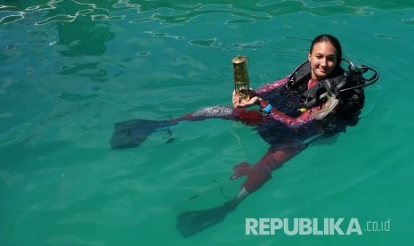 Artis Nadine Chandrawinata berenang sambil membawa obor Asian Games 2018 di perairan Raja Ampat, Papua Barat, Kamis (26/7).