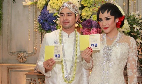 Artis sekaligus presenter Raffi Ahmad (kiri) bersama istri Nagita Slavina (kanan) menunjukan buku nikah seusai akad nikah di Jakarta, Jumat, (17/10).