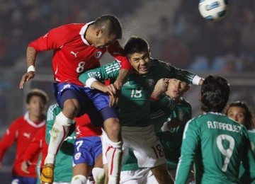 Arturo Vidal (kiri), pemain timnas Cile, melepaskan sundulan untuk membawa Cile menang 2-1 atas Meksiko.