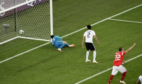  Artyom Dzyuba (kanan) mencetak gol pembuka bagi Rusia saat melawan Mesir dalam pertandingan grup A di Piala Dunia Sepak Bola 2018 di stadion St. Petersburg di St. Petersburg, Rusia, Selasa (19/6).