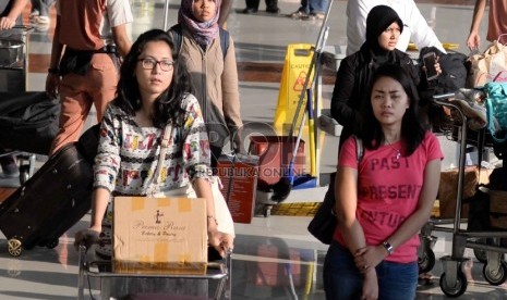 Arus Balik Bandara Soetta: Penumpang menunggu barang bawaan mereka di terminal kedatangan 1C Bandara Internasional Soekarno Hatta, Tangerang, Banten, Rabu (22/7).