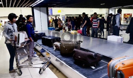 Penumpang menunggu barang bawaan mereka di terminal kedatangan 1C Bandara Internasional Soekarno Hatta, Tangerang, Banten, Rabu (22/7). (Republika/Yasin Habibi)  