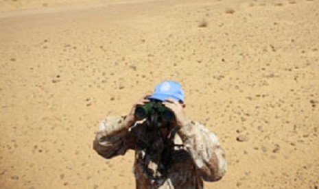 As part of MINURSO mandate, a peacekeeper on patrol uses his binoculars to monitor the ceasefire in Western Sahara. (file photo)