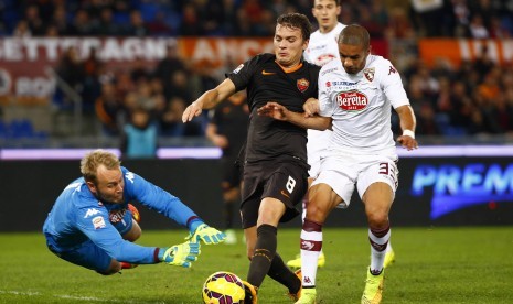 AS Roma's Adem Ljajic (C) is challenged by Torino's goalkeeper Jean Francois Gillet (L) and Bruno Peres during their Italian Serie A soccer match at the Olympic stadium in Rome November 9, 2014