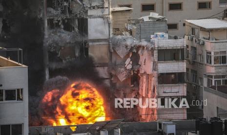 Asap dan api membumbung setelah serangan Israel di menara Al-Shorouq di Kota Gaza,  Rabu (12/5).