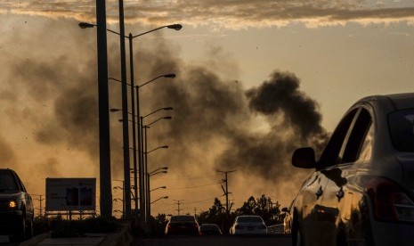 Asap dari mobil yang terbakar membumbung di tengah baku tembak di Culiacan, Meksiko, Kamis (17/10). Aksi tembak-tembakan terjadi setelah polisi menahan putra gembong narkoba Joaquin 