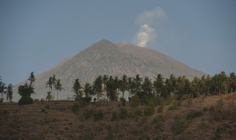 Asap mengepul dari kawah Gunung Agung yang berstatus awas terlihat dari Desa Amed, Karangasem, Bali, Jumat (29/9). 