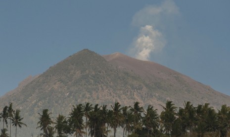 Asap mengepul dari kawah Gunung Agung yang berstatus awas terlihat dari Desa Amed, Karangasem, Bali, Jumat (29/9). 