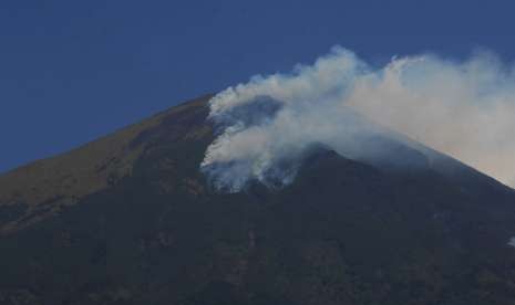 Asap mengepul dari kebakaran hutan di Gunung Sindoro terlihat dari Desa Tegalrejo, Ngadirejo, Temanggung, Jawa Tengah, Minggu (9/9). 