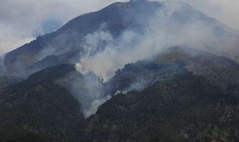 Asap mengepul dari kebakaran hutan Gunung Sumbing terlihat dari Kledung, Temanggung, Jawa Tengah, Minggu (16/9).