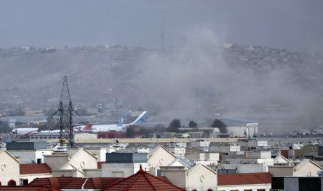 Asap mengepul dari ledakan mematikan di luar bandara di Kabul, Afghanistan, Kamis, 26 Agustus 2021. Dua pelaku bom bunuh diri dan pria bersenjata menargetkan massa yang berkumpul di dekat bandara Kabul, di hari-hari memudarnya pengangkutan udara besar-besaran yang telah menarik ribuan orang. berusaha melarikan diri dari pengambilalihan Taliban di Afghanistan.