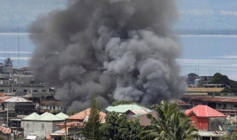 Asap mengepul di permukiman di Kota Marawi akibat pertempuran antara pasukan pemerintah dan kelompok militan Maute di Filipina, 27 Mei 2017.