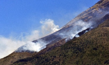 Asap putih mengepul ke udara akibat kebakaran hutan di lereng Gunung Sindoro sepekan lalu.