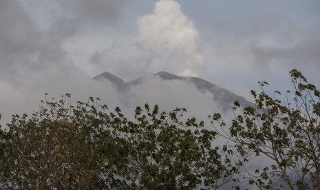 Asap putih menyembur dari kawah Gunung Agung yang saat ini masih level awas terlihat dari Desa Datah, Karangasem, Bali, Minggu (8/10).