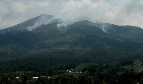 Asap tebal masih mengepul di lereng utara gunung Merbabu, di lihat dari wilayah Kecanatan Getasan, Kabupaten Semarang, Selasa (16/10). Gunung Merbabu terbakar sejak Ahad (14/10) siang dan hibgga hari ini api masih terus berkobar.