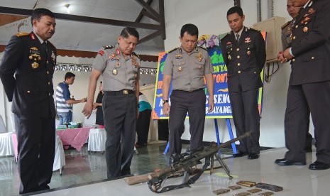 Asisten Operasi Mabes Polri Irjen Pol Unggung Cahyono (kedua kiri) bersama Kapolda Sulteng Brigjen Pol Idham Azis (kiri) memerhatikan senjata jenis M-60 yang disita dari terduga teroris Poso di Mapolda Sulawesi Tengah di Palu, Jumat (21/8).