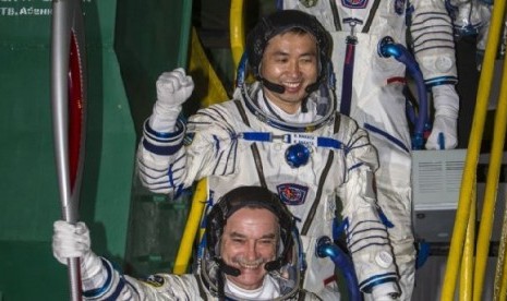 Astronot Jepang Koichi Wakata (tengah), kosmonot Rusia Mikhail Tyurin (membawa obor) dan Astronot AS Rick Mastracchio (atas, tidak terlihat) membawa obor Olimpiade dengan roket Soyuz-FG dari kosmodrome Baikonur, Kazakhstan, menuju ISS (7/11).