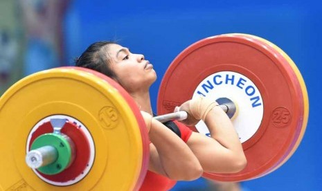 Atlet angkat besi putri Indonesia, Sri Wahyuni Agustiani, melakukan clean&Jerk; pada angkat besi 48 kg Asian Games 2014 di Moonlight Garden Venue, Inchoen, Korsel, Sabtu (20/9). 