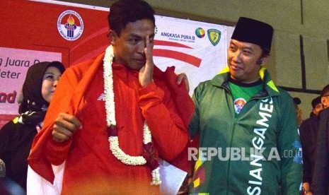 Atlet Athletik Indonesia Lalu Muhammad Zohri (kiri) bersama menteri pemuda dan olaharaga Indonesia Imam Nahrawi (kanan) menahan air mata saat tiba di Indonesia dari Finlandia di Bandara Internasional Soekarno Hatta, Tangerang,Banteng,Selasa (17/7).