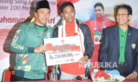 Atlet Athletik Indonesia Lalu Muhammad Zohri menerima bonus yang diberikan olej Menteri pemuda dan olaharaga Indonesia Imam Nahrawi saat tiba di Indonesia dari Finlandia di Bandara Internasional Soekarno Hatta, Tangerang,Banteng,Selasa (17/7).