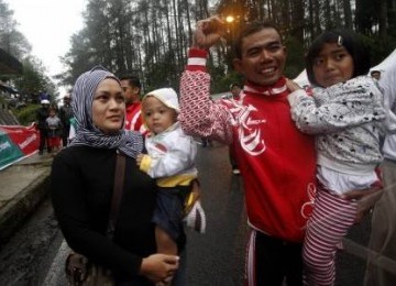 Atlet balap sepeda Indonesia, Tonton Susanto, meluapkan kegembiraan bersama istri dan anaknya usai mencapai garis finish pada nomor Individual Time Trial jarak 50 kilometer SEA Games XXVI di Jalan Raya Tangkuban Parahu, Perbatasan Bandung-Subang, Jawa Bara