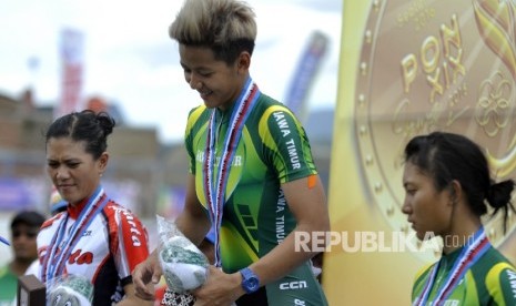 Atlet Balap Sepeda Jawa Timur Elga Kharisma Novanda (tengah) Santia Tri Kusuma (kiri) Jakarta Crismonita Dwi Putri (kanan) Jatim diatas podium usai pertandingan final dengan nomor 500 M Time Trial Putri Pada Pekan Olahraga Nasional XIX di Velodrome Munaip 