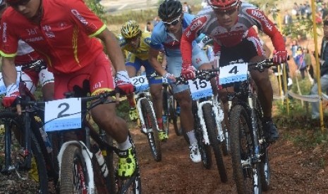 Atlet balap sepeda MTB Indonesia Chandra Rafsanzani (4) berusaha menyalip peserta lainnya pada nomor Cross Country (XC) Asian Games 27,6 km di Yeonjong Baegunsan MTB Course, Incheon, Korsel, Selasa (30/9).