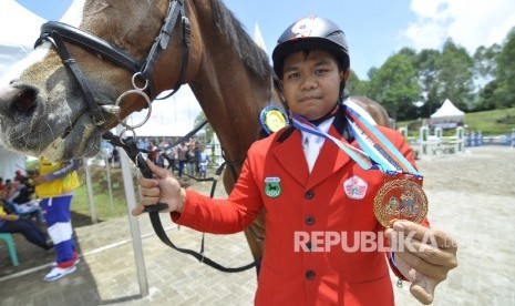 Atlet berkuda DKI Jakarta Samuel S. Prawito memperlihatkan medali usai bertanding dengan nomor Show Jumping/Lompat Rintangan Individual Competition Pembinaan pada Pekan Olahraga Nasional XIX 2016 di Pussekav Parongpong Lembang, Kabupaten Bandung Barat, 