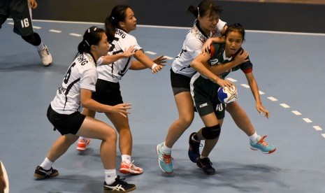 Atlet Bola Tangan Indonesia Marselina (kanan) dihadang atlet Bola Tangan Hongkong pada pertandingan pertama dalam ajang 7th Asian Women's Youth Handball Championship di GOR POPKI Cibubur, Jakarta, Minggu (20/8).