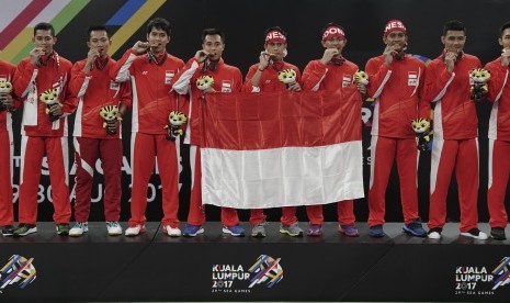 Atlet bulu tangkis beregu putra Indonesia menggigit medali emas ketika upacara penganugerahan medali bulu tangkis beregu putra SEA Games XXIX Kuala Lumpur, di Axiata Arena, Kompleks Stadion Bukit Jalil, Kuala Lumpur, Malaysia, Kamis (24/8). 