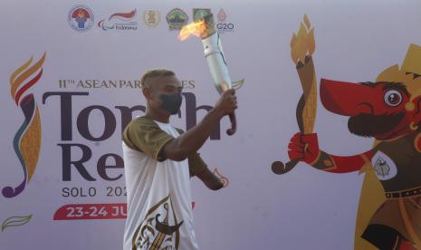 Atlet cabor para atletik National Paralympic Committee (NPC) Indonesia Rizal Bagus Saktyono membawa api obor saat torch relay atau pawai obor ASEAN Para Games 2022 di Stadion Sriwedari, Solo, Jawa Tengah, Ahad (24/7/2022). Indonesia menjadi tuan rumah ajang ASEAN Para Games XI 2022 yang akan mempertandingkan 14 cabang olahraga dan diikuti 11 negara-negara Asia Tenggara pada 30 Juli-6 Agustus 2022 mendatang.