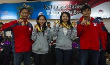  Atlet catur peraih medali emas Sea Games XXVII Myanmar, Susanto Megaranto (kanan), Irene Kharisma Sukandar (kedua kanan), Chelsie Monica Sihite (kedua kiri) dan Muhammad Lutfi Ali (kiri) saat tiba di Bandara Soekarno Hatta, Tangerang, Ahad (22/12).  (Anta