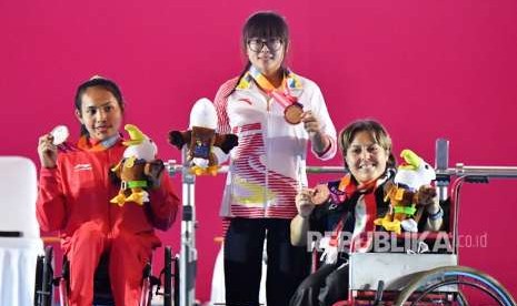 Atlet Cina Cui Zhe (tengah) bersama Atlet Indonesia Ni Nengah Widiasih (kiri) dan Atlet Suriah Noura Baddour (kanan) mengangkat medali Women's Up to 41 kg Group A para powerlifting Asian Para Games 2018 di Balai Sudirman, Jakarta, Ahad (7/10).