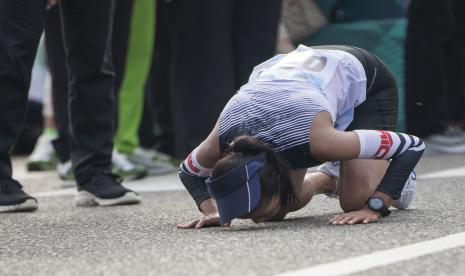 Atlet DI Yogyakarta Indah Lupita Sari bersujud syukur usai mencapai garis finis dalam nomor jalan cepat 20 kilometer putri PON Papua di kompleks Freeport, Kuala Kencana, Kabupaten Mimika, Papua, Sabtu (9/10/2021). Indah berhasil meraih medali emas, sementara atlet Jawa Timur Ari Indah Aprilia meraih medali perak dan atlet Kalimantan Selatan Halida Ulfah meraih medali perunggu. 