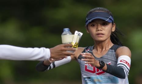 Atlet DI Yogyakarta Indah Lupita Sari (kiri) mengambil air minum dan makanan saat bertanding dalam nomor jalan cepat 20 kilometer putri PON Papua di kompleks Freeport, Kuala Kencana, Kabupaten Mimika, Papua, Sabtu (9/10/2021). Indah berhasil meraih medali emas, sementara atlet Jawa Timur Ari Indah Aprilia meraih medali perak dan atlet Kalimantan Selatan Halida Ulfah meraih medali perunggu.