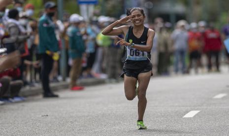 Atlet DKI Jakarta Odekta Elvina Naibaho melakukan hormat saat akan finis dalam nomor lari maraton putrI PON Papua di kompleks Freeport, Kuala Kencana, Kabupaten Mimika, Papua, Sabtu (9/10/2021). Odekta berhasil meraih medali emas, sementara atlet DKI lainnya Tryaningsih meraih medali perak dan atlet Kalimantan Timur Irma Handayani meraih medali perunggu.