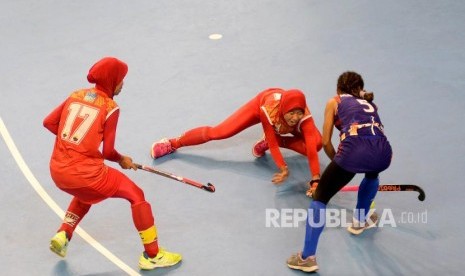 Atlet Hoki Indoor putri DKI Jakarta Annur Amalia El Islamy (kiri) bersama Ika Oktaviani (tengah) menghadang pemain Papua Maryana (kanan) pada final PON XIX di Gymnasium FPOK UPI, Bandung, Jawa Barat