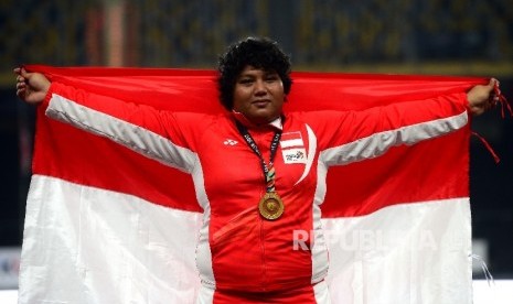 Atlet Indonesia Eki Febri Ekawati saat pengalugan medali usai mendapat medali emas nomor tolak peluru putri SEA Games XXIX Kuala Lumpur di Stadion Bukit Jalil, Kuala Lumpur, Malaysia, Jumat (25/8) malam.