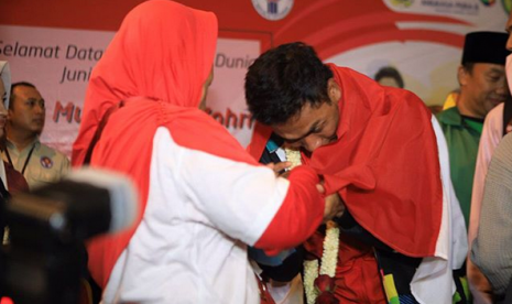 Atlet lari yang berhasil meraih juara dunia lari 100 meter, Lalu Muhammad Zohri menangis saat diselimuti bendera merah putih oleh kakaknya dalam penjemputan kedatangannya di Bandara Soekarno Hatta, Selasa (17/7) malam.