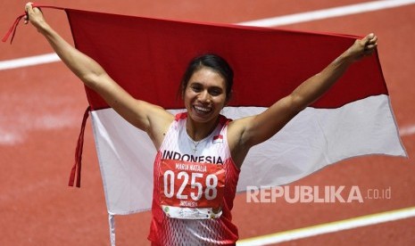 Atlet lompat jauh Indonesia Maria Natalia Londa membentangkan Bendera Merah Putih setelah berhasil memenangkan pertandingan Final Lompat Jauh Putri SEA Games ke-30 di Stadion Atletik New Clark, Filipina, Ahad (8/12/2019). 