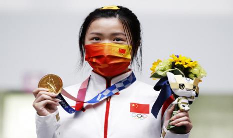 Atlet menembak asal China, Qian Yang, memamerkan medali emas yang diraihnya dari nomor air rifle 10 meter putri, Sabtu (24/7). Yang menjadi atlet pertama yang meraih emas pada Olimpiade Tokyo. 