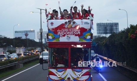 Atlet Olimpiade yang diarak menggunakan Bandung Tour On Bus (Bandros) menyapa warga saat tiba di Terminal 3 baru Bandara Soekarno-Hatta, Tangerang, Banten, Selasa (23/8).