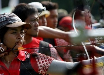 Atlet panahan Dellie Threesyandinda (kiri) bersiap membidik saat berlatih bersama dengan atlet Myanmar di Jakarta, Jumat (11/11). 