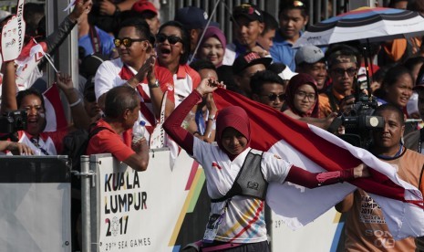 Atlet panahan Indonesia Diananda Choirunnisa membawa bendera merah putih seusai mengalahkan lawannya asal Filipina Nicole Marie Tagle pada final nomor recurve putri di Synthetic Turf Fild, Kawasan Bukit Jalil, Malaysia, Ahad (20/8). 