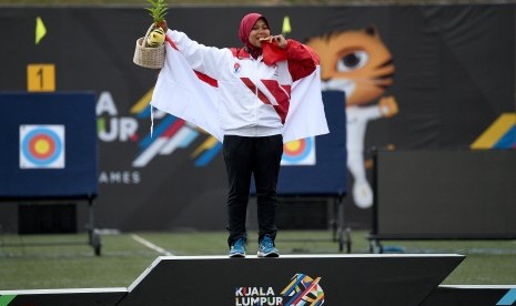 Atlet panahan putri Indonesia Sri Ranti menggigit medali emas setelah menjuarai final nomor compound putri SEA Games XXIX di Synthetic Turf Fild, kawasan Stadion Bukit Jalil, Kuala Lumpur, Malaysia, Rabu (16/8). 